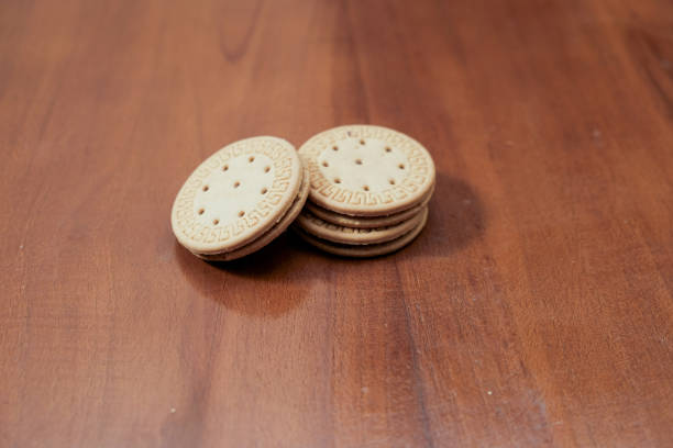 Stack of Sandwich cookies, chocolate cream filled biscuits on the rustic wooden background. Sweet food, advertisement food
