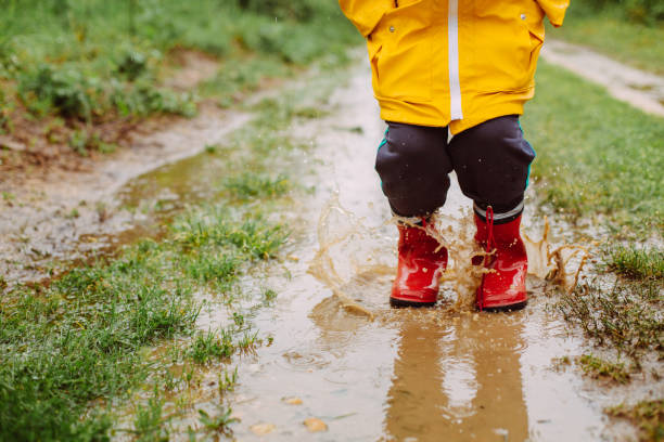 istock Rainy Day Fun: A Boy's Joyful Adventure in the Muddy Puddles 2198054813