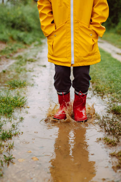istock Rainy Day Fun: A Boy's Joyful Adventure in the Muddy Puddles 2198054833