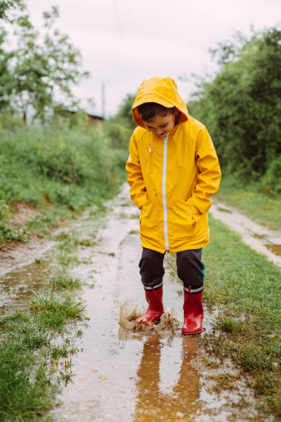 istock Rainy Day Fun: A Boy's Joyful Adventure in the Muddy Puddles 2198054891