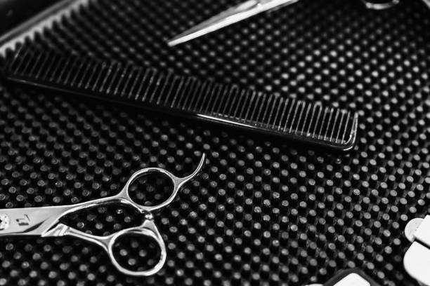 Hairdressing scissors, a comb, and styling accessories are organized on a workstation mat.