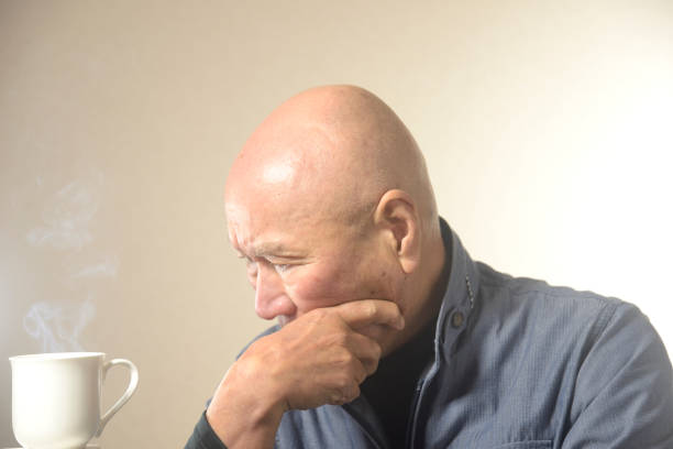 Steaming hot drink and troubled old man