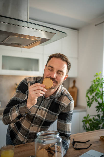 istock Man with a cookie in hand, enjoying a sweet moment 2198062072