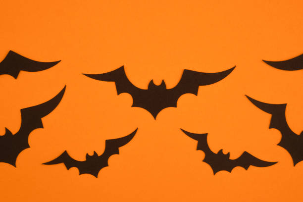 istock Black bats flying against an orange background during Halloween decoration preparation 2198065048