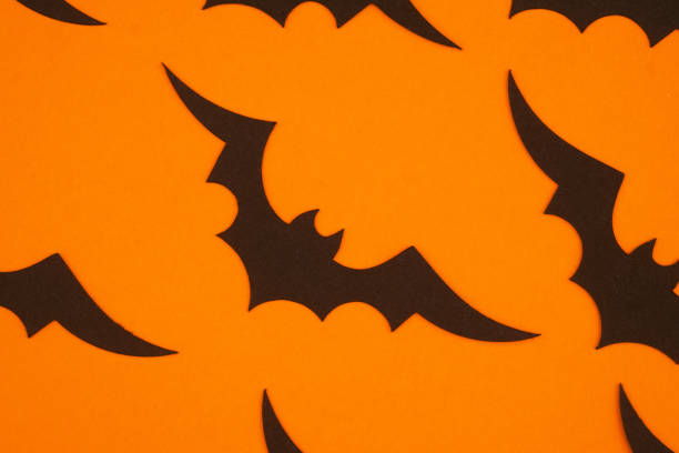 istock Black bats on bright orange background create a festive Halloween atmosphere for decorations 2198065080