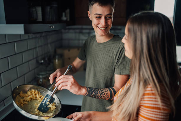 istock Lesbian couple cooking scrambled eggs in kitchen 2198065287