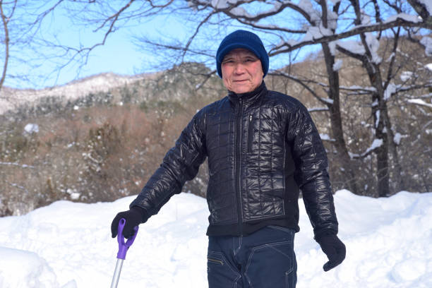 istock A smiling old man using a snow plow to remove snow in a snowy area 2198067274
