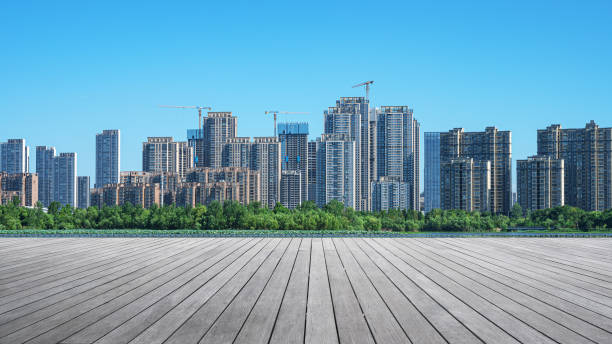 istock Empty wooden platform with modern urban skyline and sunny blue sky background 2198085883