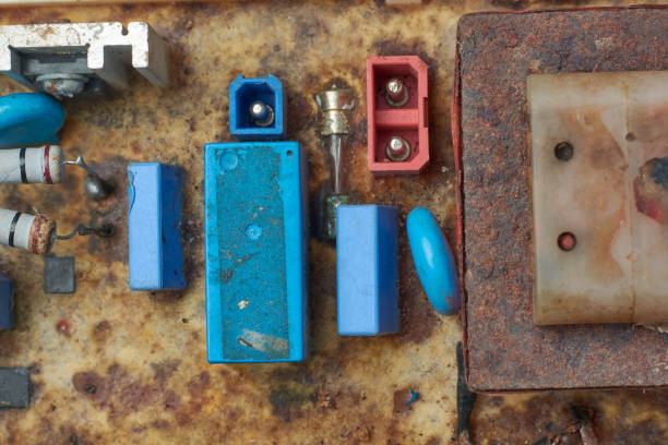 close-up of damaged or disassembled various components of circuit board of electronic device, corroded transformer and connectors, taken from above