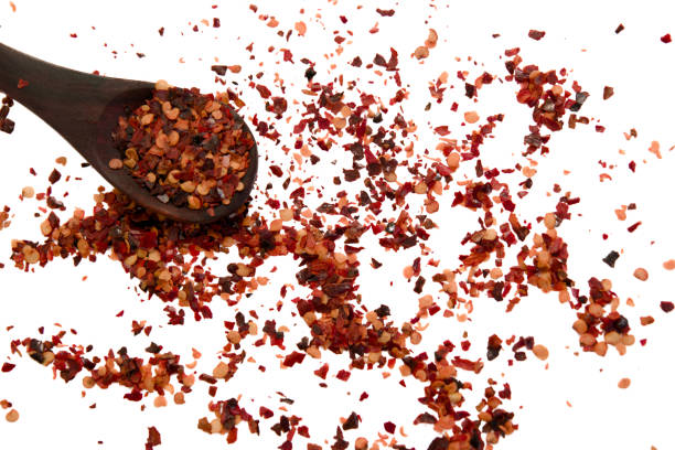 istock Red chili flakes on white background with spoon 2198089082
