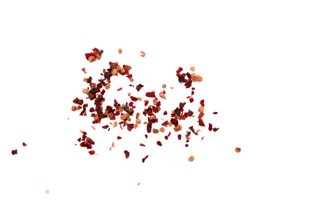 Dried chili flakes scattered on a white background