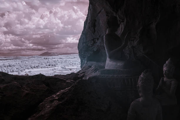 Infrared color, a cave with several Buddha statues positioned inside
