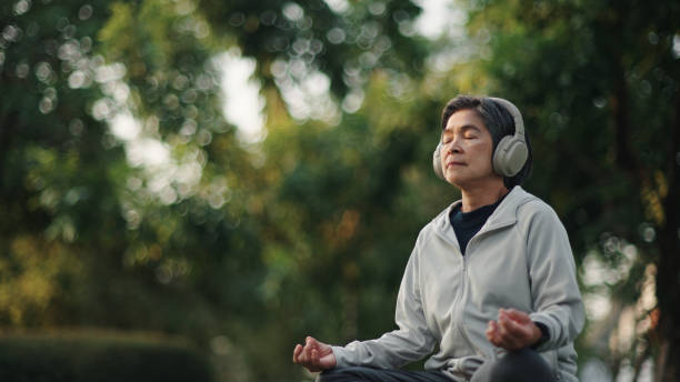 istock Senior woman meditating at park. 2198093109