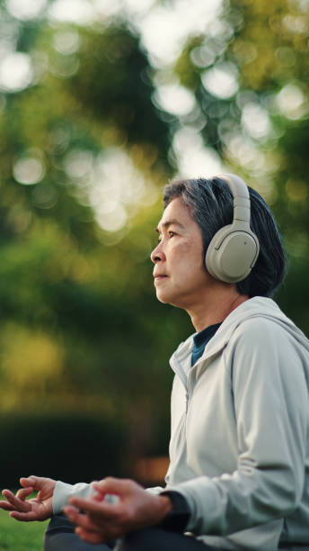 istock Senior woman meditating at park. 2198093693