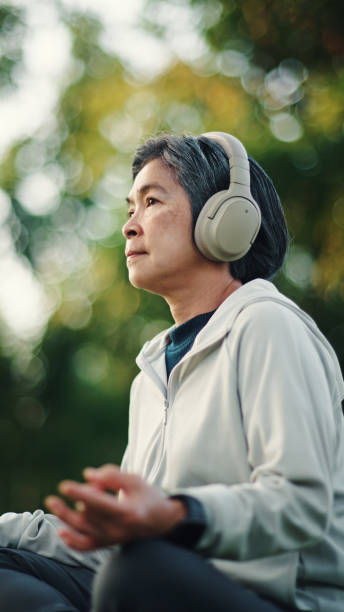 istock Senior woman meditating at park. 2198093694