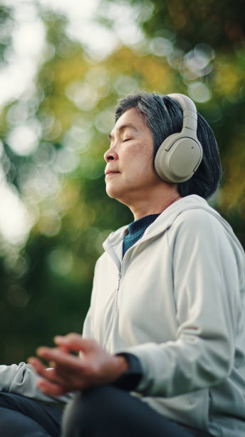 istock Senior woman meditating at park. 2198093697