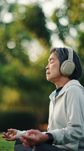 istock Senior woman meditating at park. 2198093703