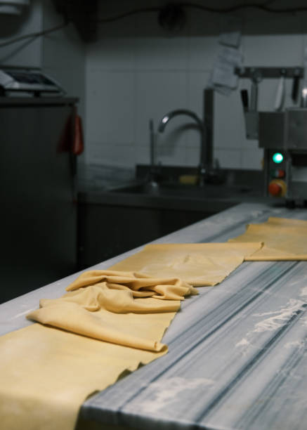 istock Freshly prepared sheets of handmade pasta on a floured work surface in an Italian restaurant kitchen, showcasing traditional pasta-making techniques for authentic Italian cuisine 2198102411