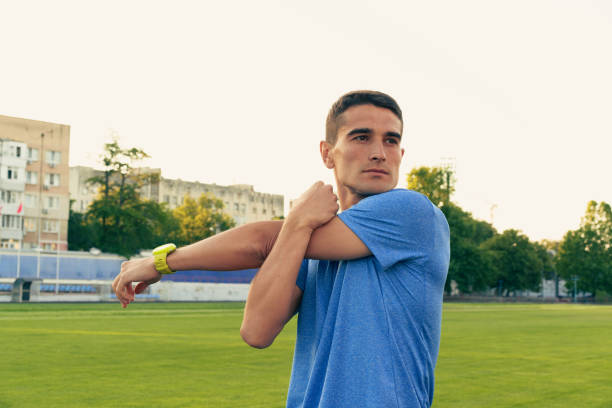 istock Young athlete stretches before training on a grassy field in the late afternoon sun 2198105092