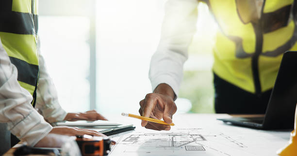 istock Architecture, floor plan and hands of business people with blueprint for urban development, design and building. Construction, engineering and workers with pencil for teamwork, collaboration or ideas 2198106798