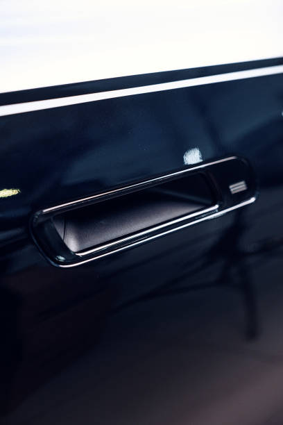istock Car door handle gleaming under indoor lighting, showcasing modern design and craftsmanship 2198107546