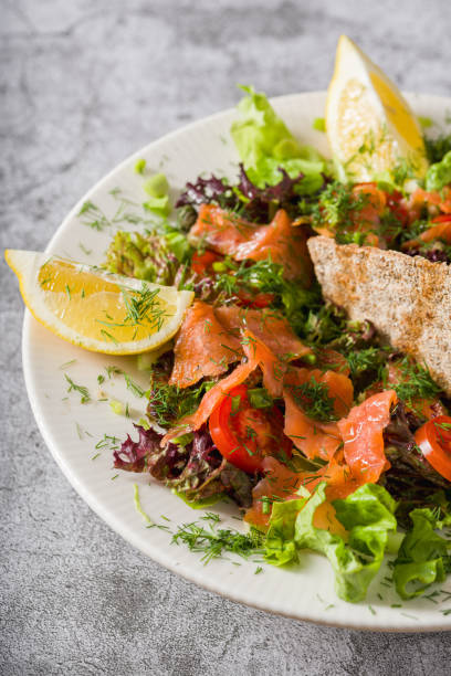 istock Salad with smoked salmon on stone table. Healthy eating concept 2198108217
