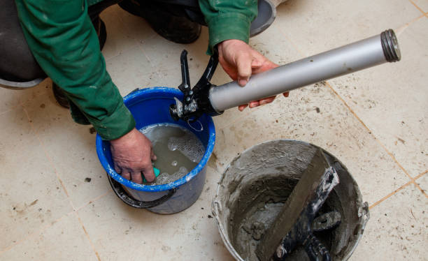 istock A man is working on a project, using a blue bucket and a tube 2198110239