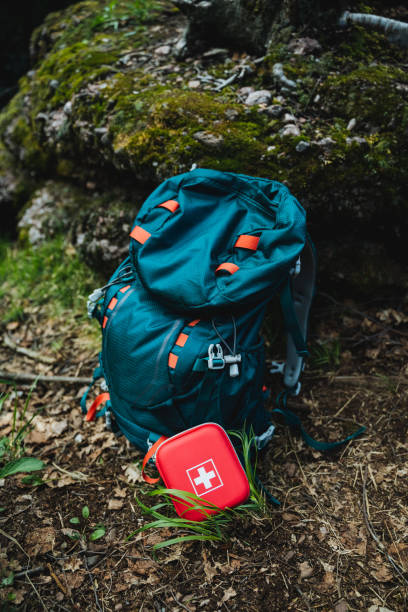 istock A electric blue backpack is placed on the grass next to a red first aid kit. The backpack is a piece of luggage used for recreation and contains personal protective equipment 2198112319