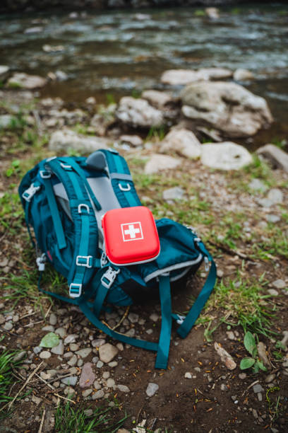 istock A motor vehicle is parked on electric blue grassland with a backpack and first aid kit on top. The landscape is filled with plant and soil, perfect for recreation and travel 2198112333