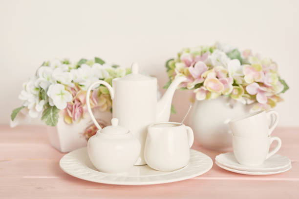Set of white dishes on table on light background.