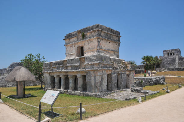 Tulum, Mexico- May 16, 2013: The Mayan city of Tulum stands 130 km south and 700 years away from Cancun. Tulum was once a mighty walled city built by the Mayan people. The Tulum Ruins are one of the most well preserved Mayan sites along Mexico’s coast and provide a glimpse of how the Mayans lived and why they were a renowned civilization. This impressive Tulum archaeological site sits on the edge of a steep cliff. It overlooks the gorgeous Caribbean Sea. Right below the site lies the Tulum Ruins Beach, one of the area’s best beaches. Here is  the main ruins in the Tulum city.
