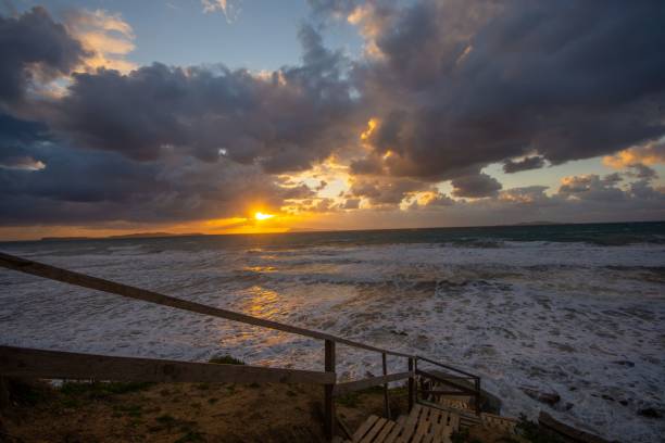 istock Dramatic sunset over ocean with beach stairs. 2198115078
