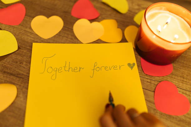 istock Writing a Heartfelt 'Together Forever' Message Amidst Decorative Hearts and Candlelight 2198118022