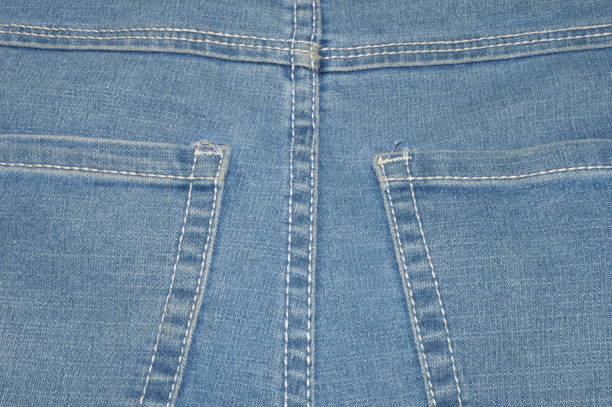 clothing items washed cotton fabric texture with seams, clasps, buttons and rivets, macro