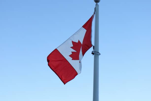 istock canadian flag against bright blue sky 2198123685