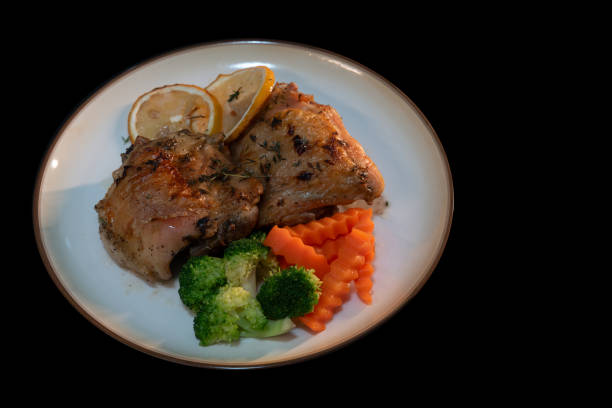 istock Baked Chicken Thighs with Lemon on black background. 2198125003