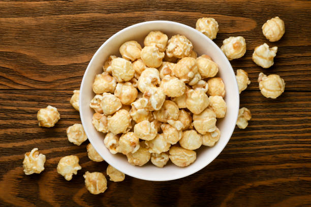 istock Caramel popcorn in a plate on a wooden background. Top view 2198125855