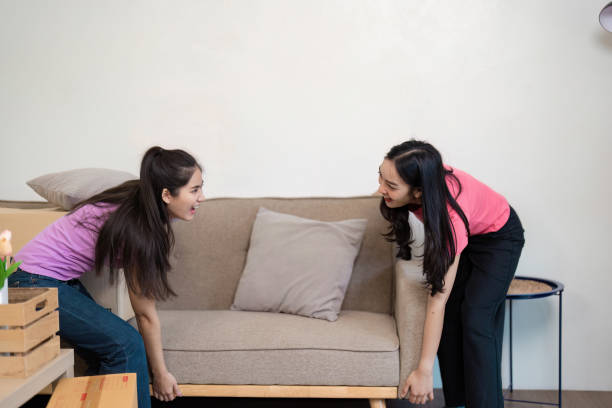 istock LGBT couple joyfully moving a couch together into their new home, teamwork on display 2198126313