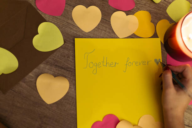 istock Writing a Heartfelt 'Together Forever' Message Amidst Decorative Hearts and Candlelight 2198126599