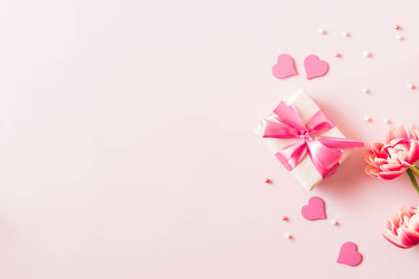 istock Pink tulips and hearts, gift box with ribbon on light pink background 2198126853