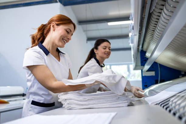 istock Dry cleaning service. Folding clean laundry and preparing for packing. 2198127415