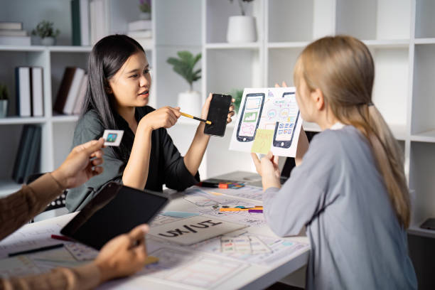 istock Engaging UX UI design discussion with mobile app prototypes and team feedback. 2198127985