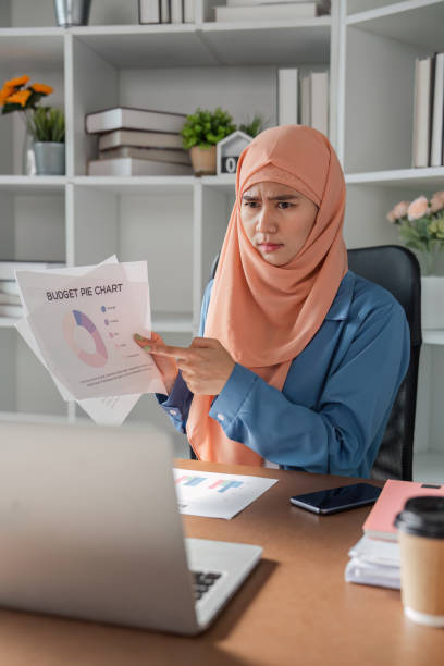istock Diverse female accountant questioning a budget pie chart while reviewing it on a laptop in an office. 2198128777