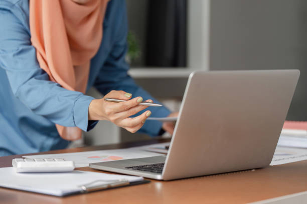 istock Diverse Muslim woman analyzing data on laptop while preparing financial report. 2198128838