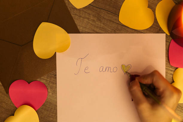 istock Handwriting 'Te Amo' Surrounded by Colorful Paper Hearts and Candlelight 2198128914