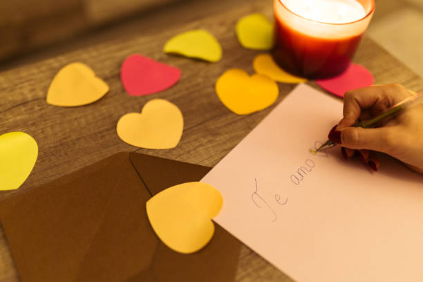 istock Handwriting 'Te Amo' Surrounded by Colorful Paper Hearts and Candlelight 2198128933