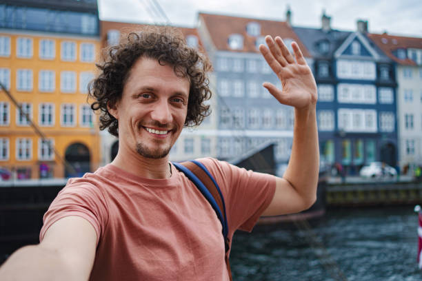 istock Smiling man taking selfie in nyhavn, copenhagen 2198129620