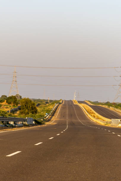 isolated empty tarmac road with bright sunset sky at evening