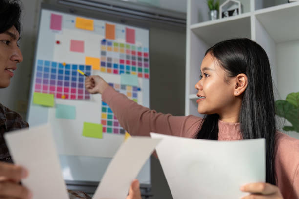 istock Diverse graphic design team discussing color palettes and project ideas. 2198130815