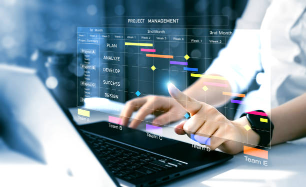 istock Project manager working on laptop and updating tasks and milestones progress planning with Gantt chart scheduling interface for company on virtual screen.  Business Project Management System. 2198130898
